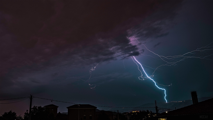 Lightning storm over a town at night