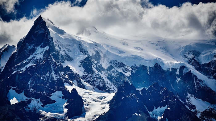 Snow-covered mountains under a cloudy sky