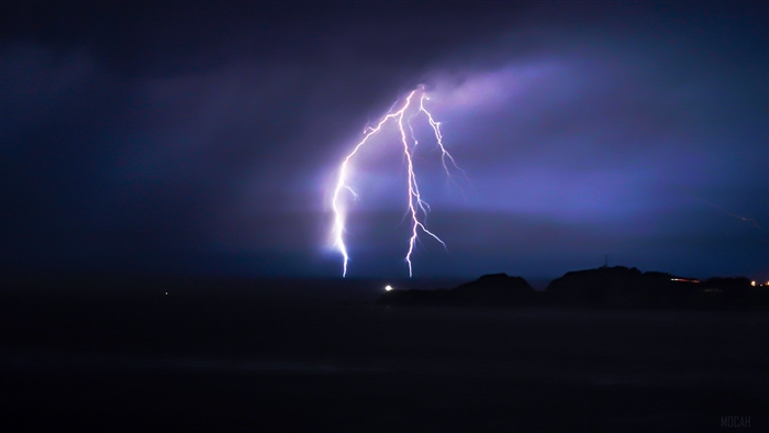 Lightning striking over the ocean at night 4K