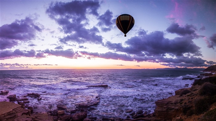 Hot air balloon over the sea at sunset 4K