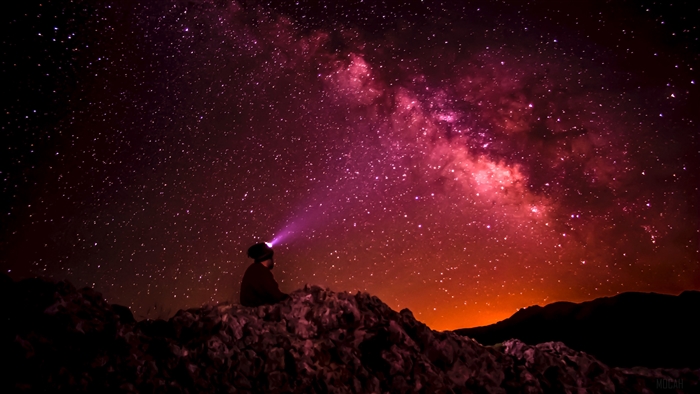 Man with headlamp looking at starry sky