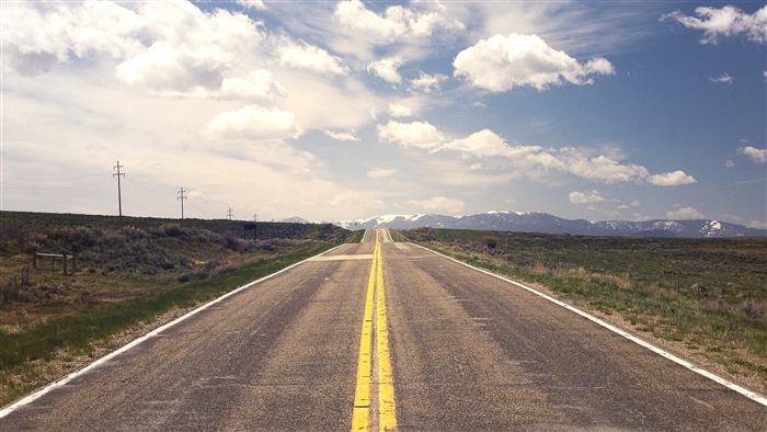 Road stretching to snow-capped mountains