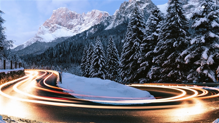 Snowy mountain road with light trails