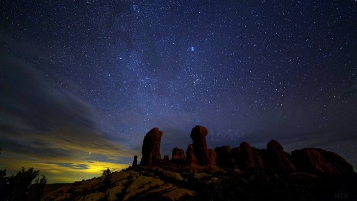 Starry night sky over rock formations