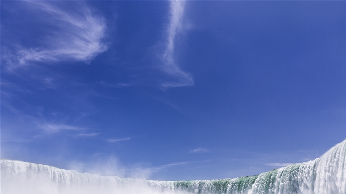 Niagara Falls waterfall under a blue sky with clouds