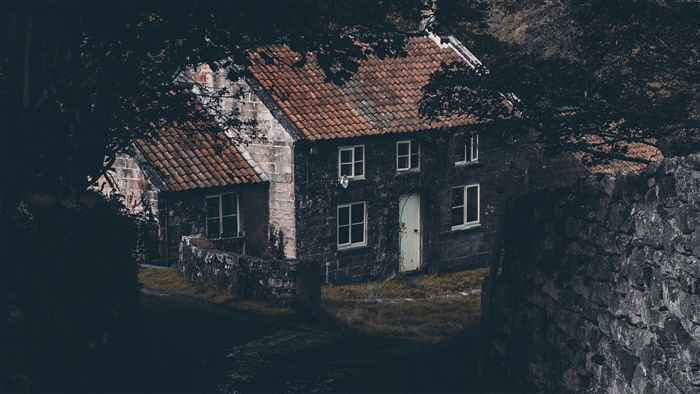 Stone house with tiled roof in a forest