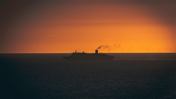 Ship sailing on the ocean at sunset 4K