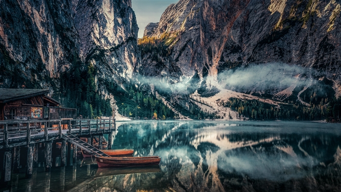 Wooden cabin and boats on a lake in the Dolomites, Italy 4K