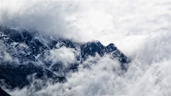 Snow-capped mountains shrouded in fog