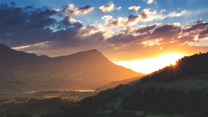 Sunset over mountains and lake with clouds