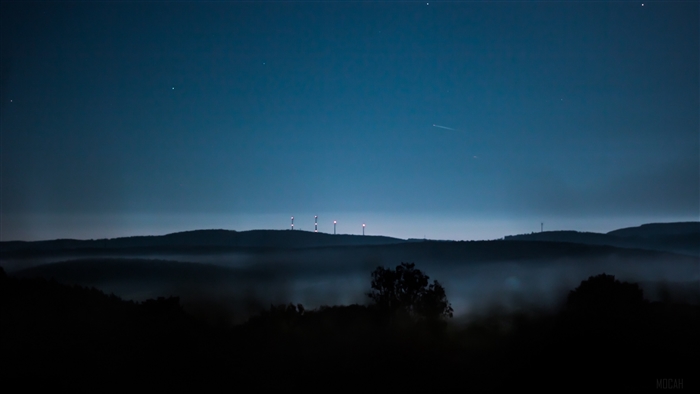 Night landscape with fog and wind turbines