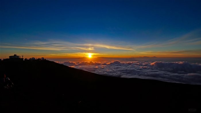 Sunset over clouds with observatories