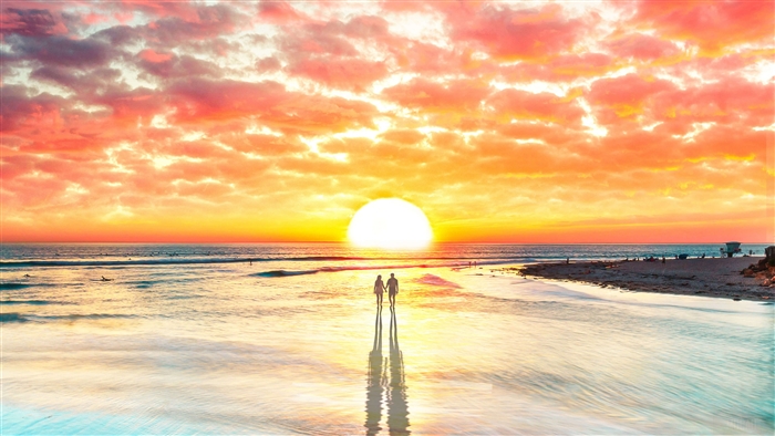 Couple walking on beach at sunset 4K