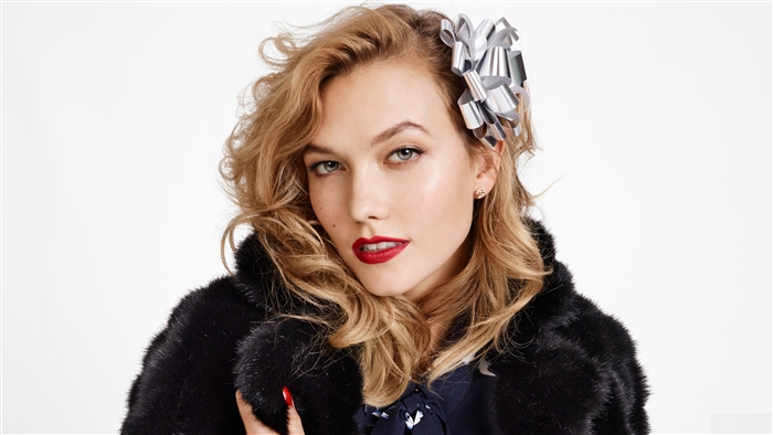 Karlie Kloss wearing a black fur coat with a silver bow in her hair