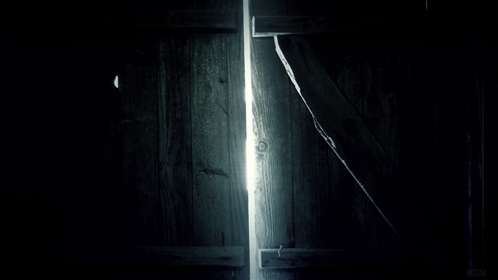 Wooden door cracked open with light