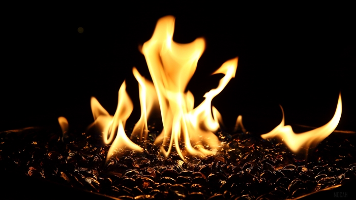 Fiery flames over dark glass rocks 4K