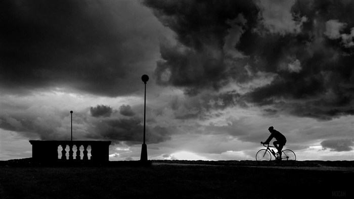 Bicyclist silhouette against stormy clouds