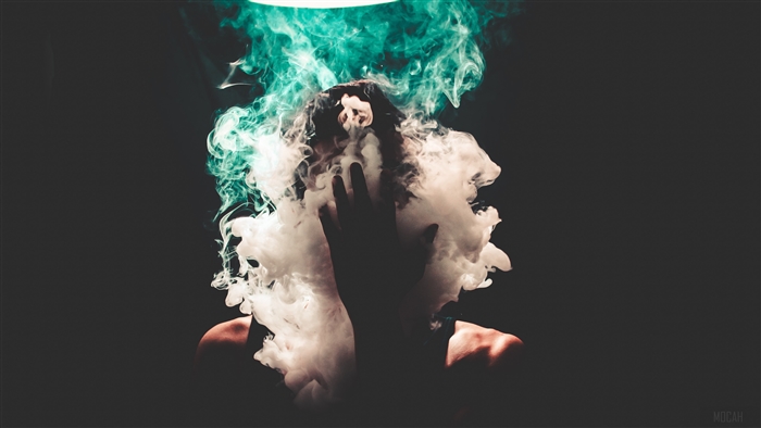 Person covered in smoke with teal light