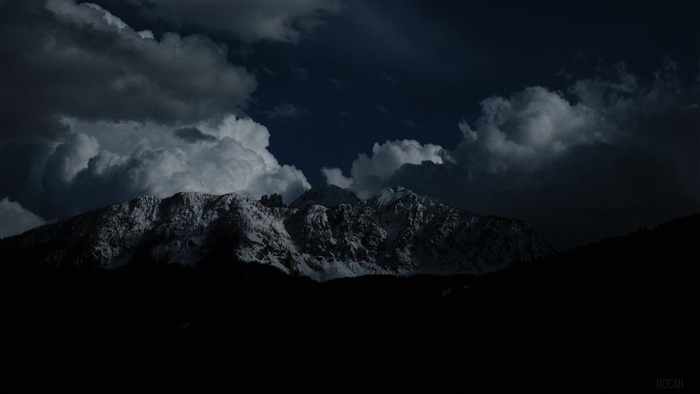 Snowy mountains at night under dramatic clouds 4K