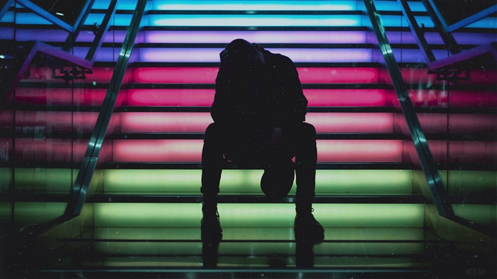 Man sitting on colorful illuminated stairs