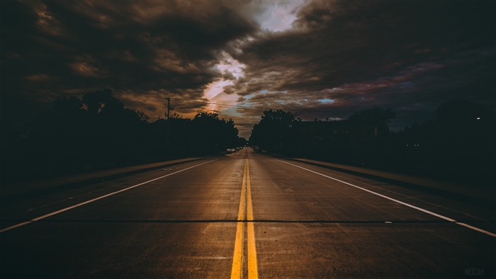 Road with double yellow lines under cloudy sky