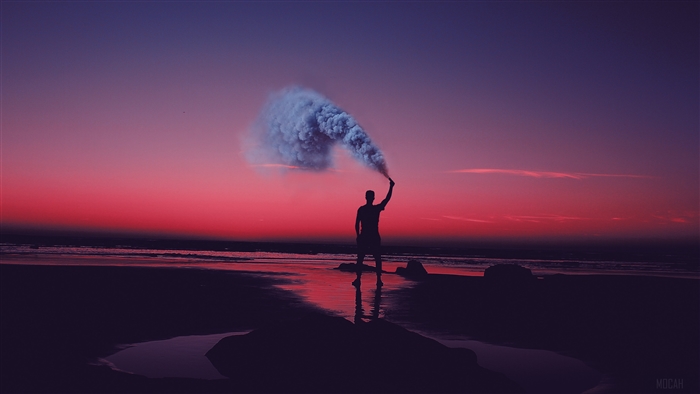 Silhouette with Smoke Flare on Beach at Sunset