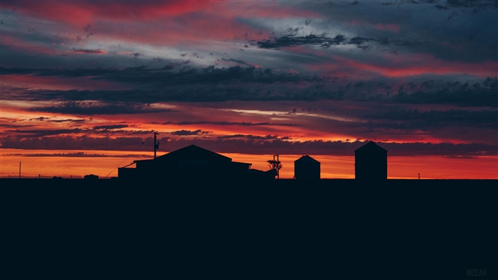 Sunset over farm buildings with cloudy sky 4K
