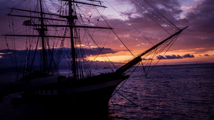 Silhouette of a tall ship at sunset over the sea 4K