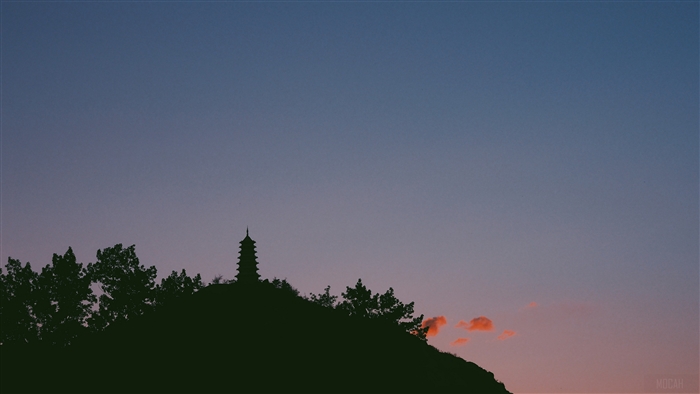 Silhouette of a temple on a hill at dusk