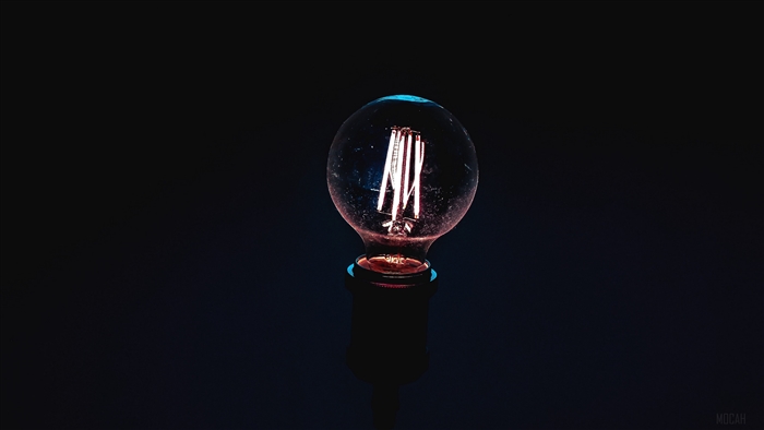Light bulb with filament on black background 4K