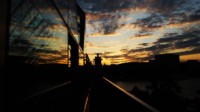 Sunset over city with reflection in glass building