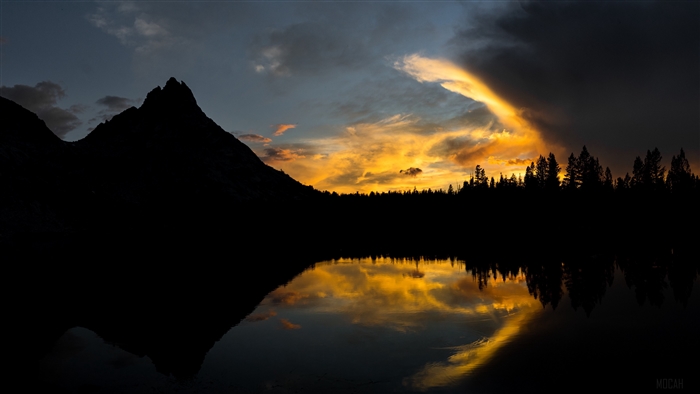 Sunset over a mountain lake with trees