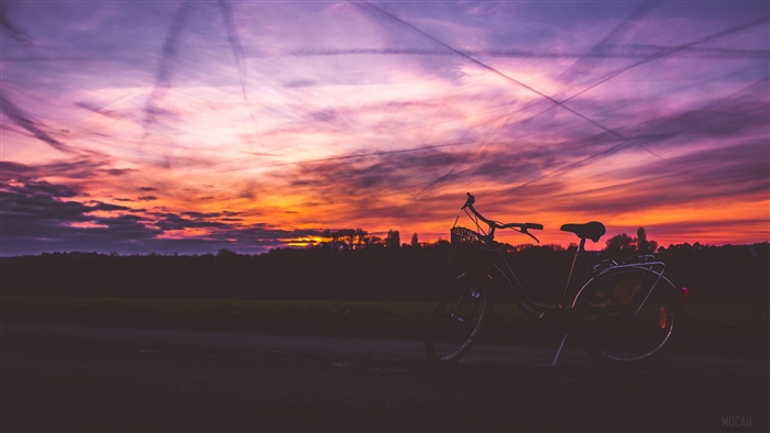 Bicycle silhouetted against a colorful sunset sky