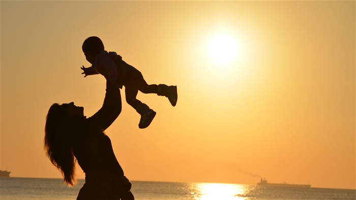 Mother holding child at sunset 4K