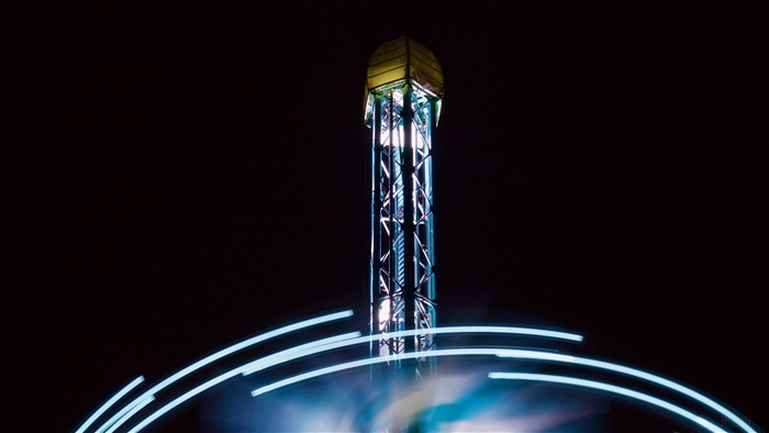 Drop tower ride at night with light trails
