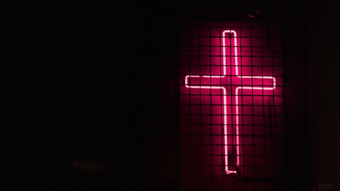 Pink neon cross on mesh