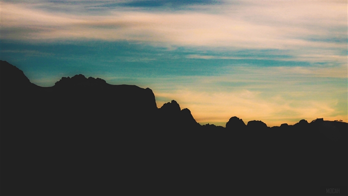 Silhouette of mountains against a colorful sky