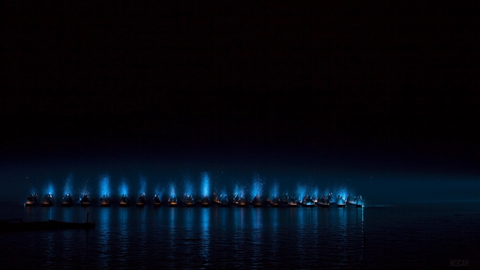 Boats with blue lights on the sea at night