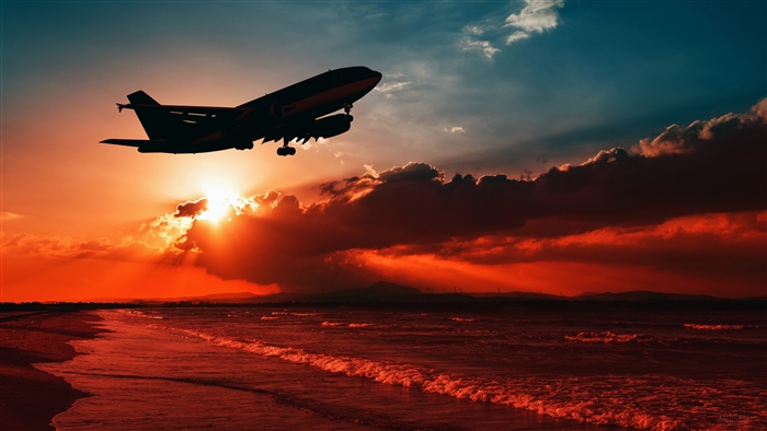 Airplane taking off over the sea at sunset silhouette 4K
