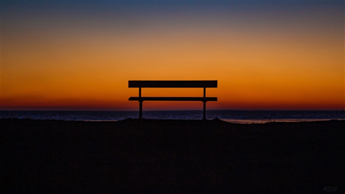 Bench on a beach at sunset 4K
