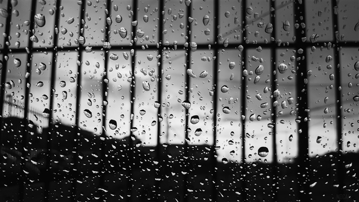 Raindrops on glass with bars and silhouette