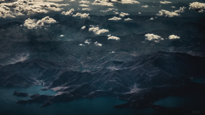 Aerial view of dark mountains and lake with clouds