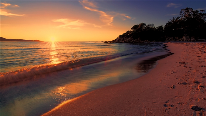 Sunset over a beach with long exposure waves