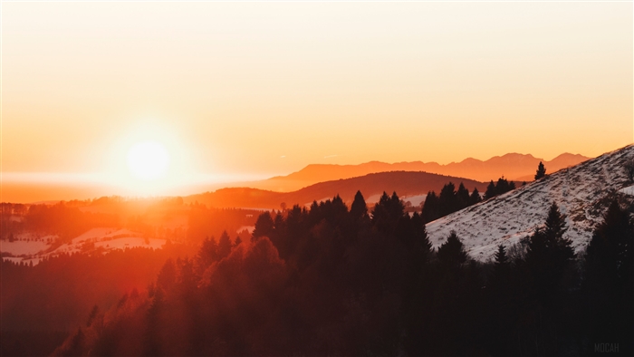 Sunset over forested mountains