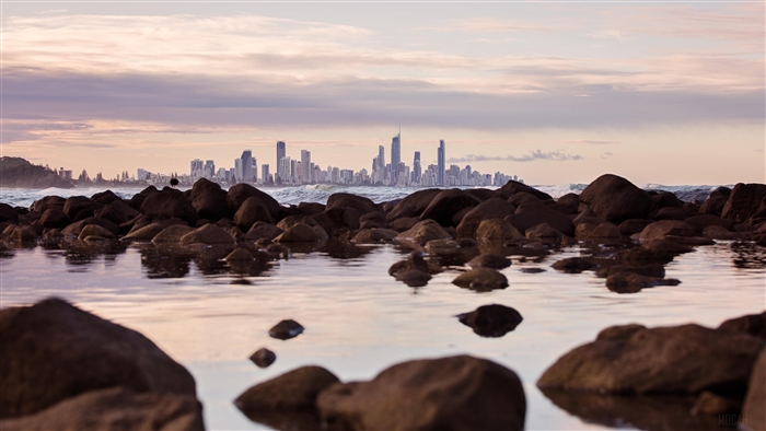Seashore Rocks With City Skyline View 4K