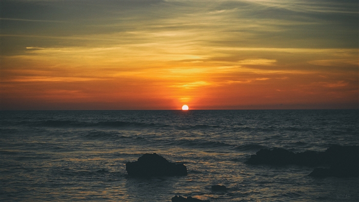 Sunset over the ocean with rocks