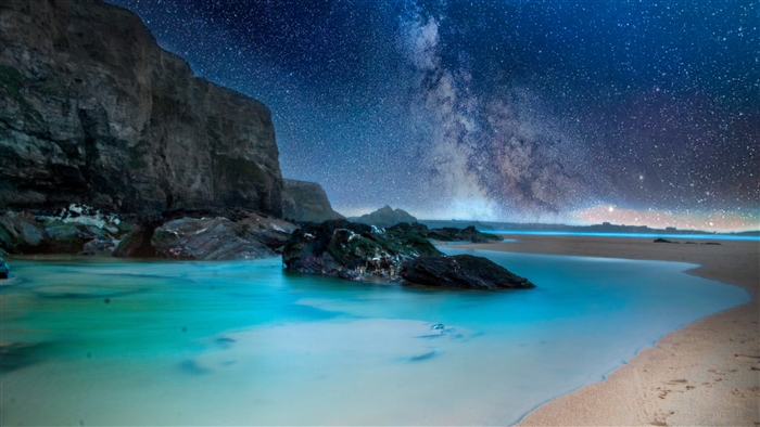 Milky Way over a rocky coastline at night