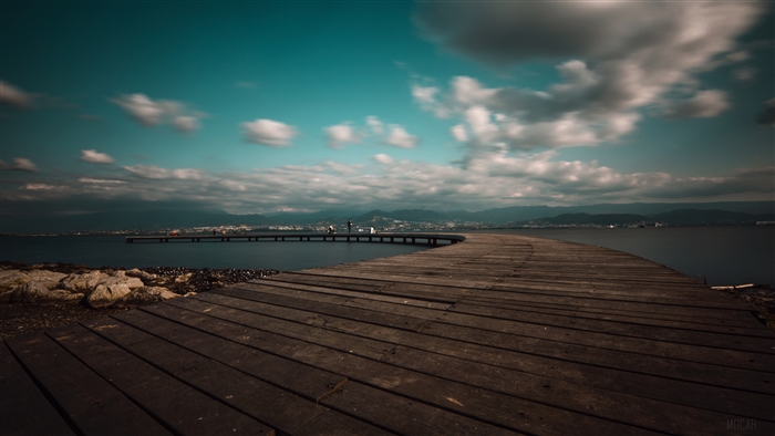 Wooden pier on a lake with mountains in the background