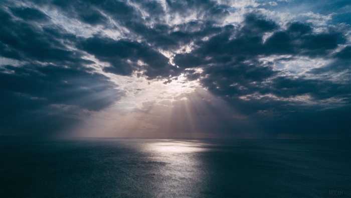 Sun Rays Breaking Through Clouds Over Ocean