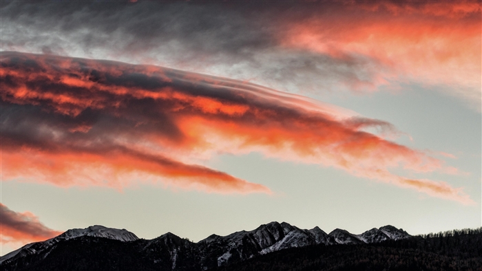 Sunset clouds over snow-capped mountains
